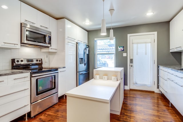 kitchen featuring pendant lighting, stainless steel appliances, dark wood-type flooring, and white cabinets