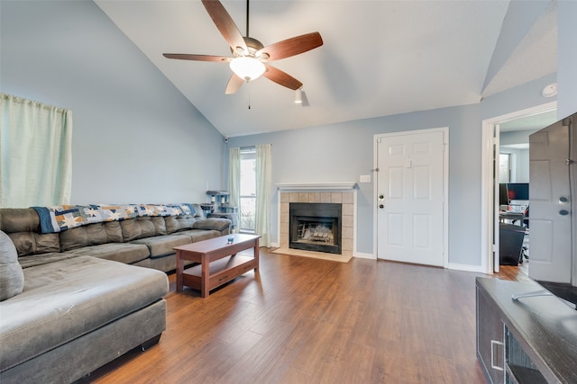 living room with a fireplace, ceiling fan, dark wood-type flooring, and vaulted ceiling