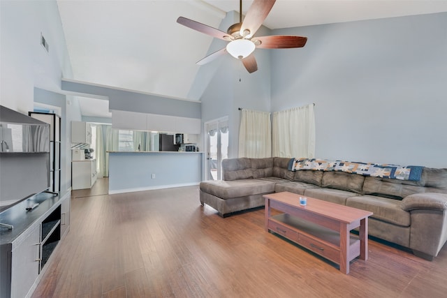 living room with ceiling fan, hardwood / wood-style floors, and high vaulted ceiling