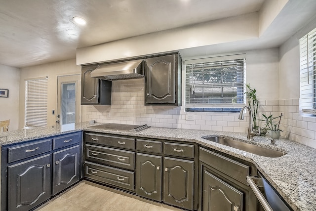 kitchen with appliances with stainless steel finishes, tasteful backsplash, sink, a healthy amount of sunlight, and wall chimney exhaust hood