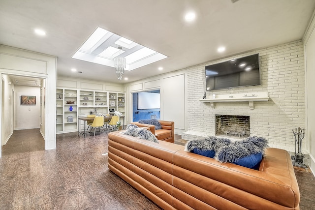 living room featuring built in features, a notable chandelier, and a brick fireplace