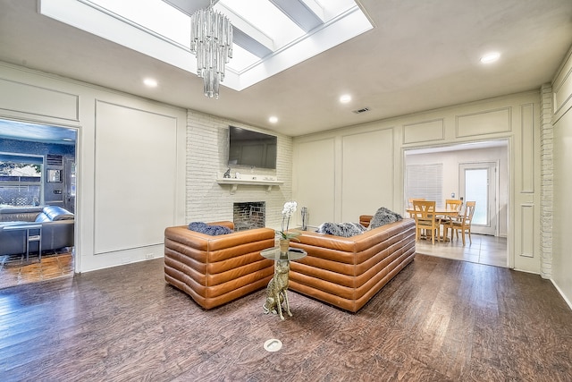 living room featuring dark hardwood / wood-style floors, a chandelier, and a fireplace