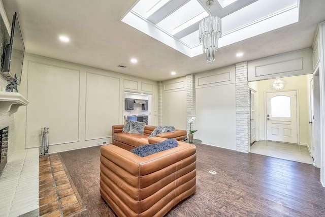 living room with a brick fireplace, dark tile patterned flooring, and a notable chandelier