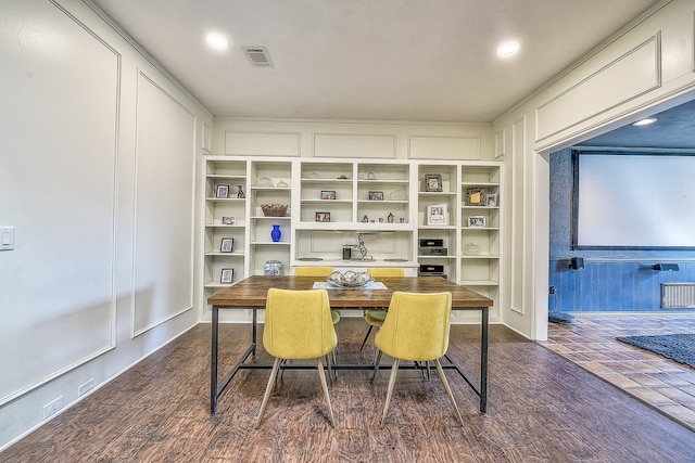 dining room with built in shelves and dark wood-type flooring