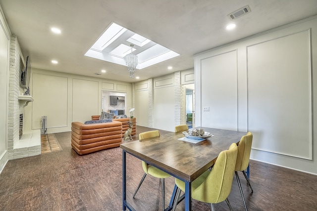 dining space featuring a skylight and a fireplace