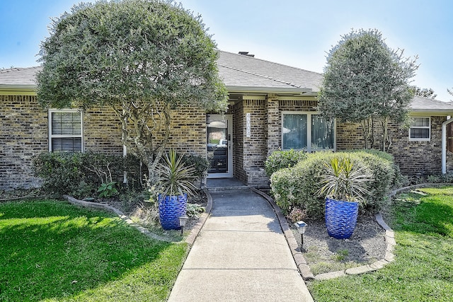 view of exterior entry featuring a yard