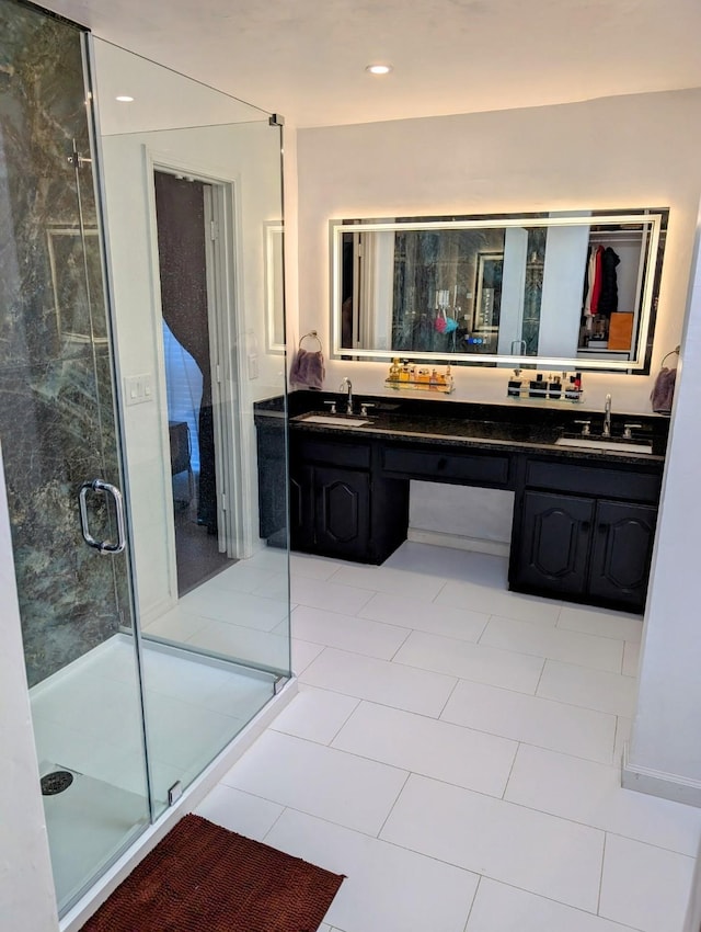 bathroom with a shower with shower door, tile patterned floors, and vanity