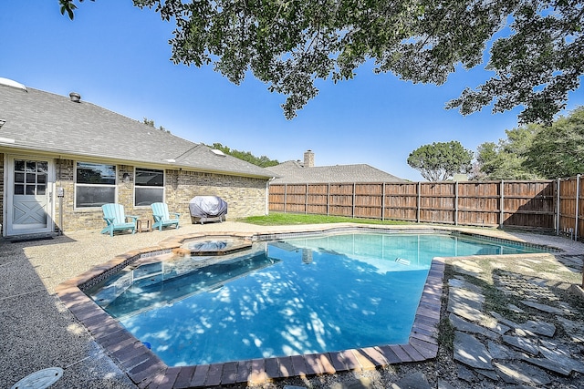 view of pool with an in ground hot tub, a patio area, and a grill