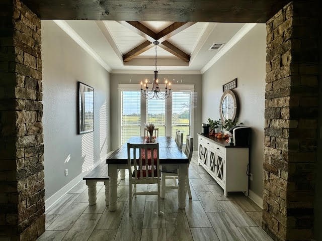 dining area featuring crown molding, beamed ceiling, coffered ceiling, and a chandelier