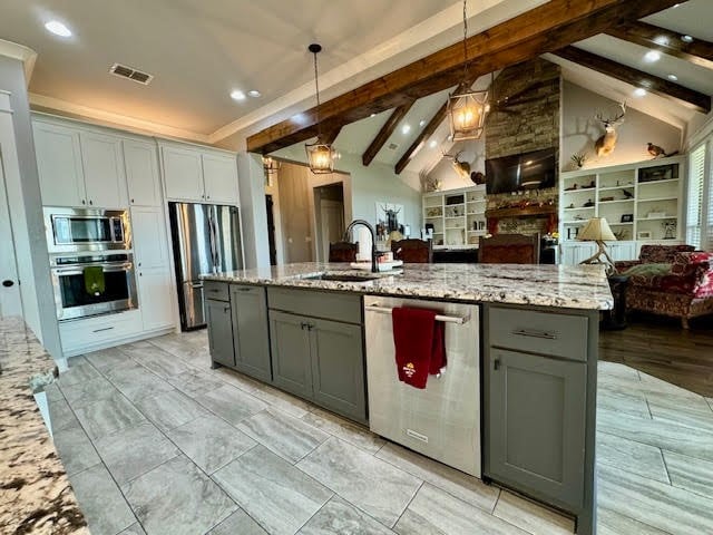 kitchen featuring stainless steel appliances, gray cabinets, and vaulted ceiling with beams