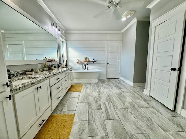 bathroom featuring a tub to relax in, ceiling fan, vanity, wood-type flooring, and crown molding