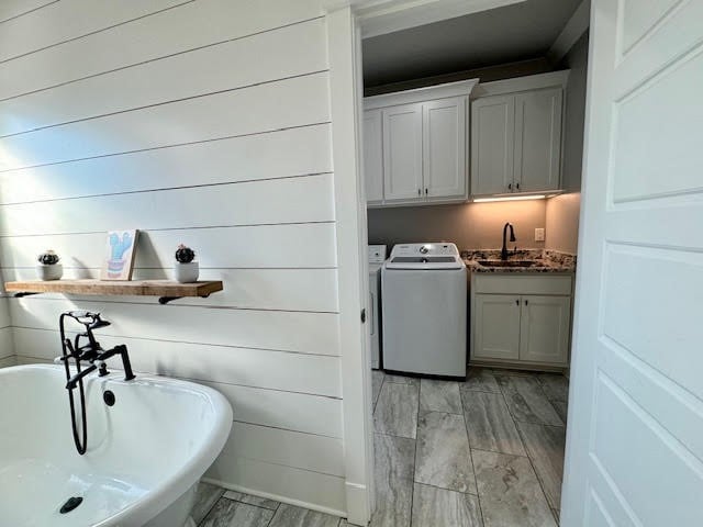 laundry area with washing machine and dryer, sink, and cabinets