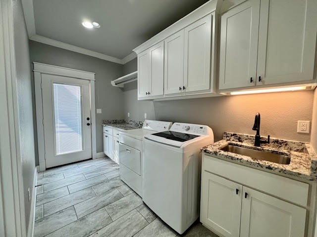 laundry room with washer and clothes dryer, ornamental molding, cabinets, and sink