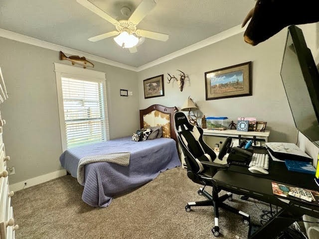 carpeted bedroom with ceiling fan and ornamental molding