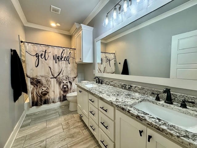 full bathroom featuring ornamental molding, shower / bath combo, vanity, and toilet