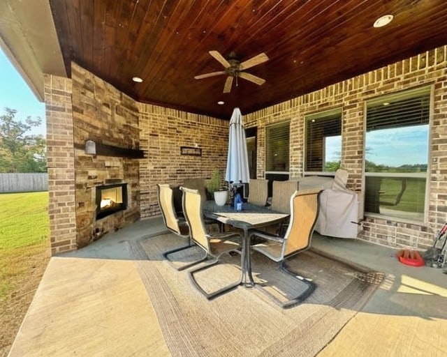 view of patio / terrace featuring an outdoor stone fireplace and ceiling fan