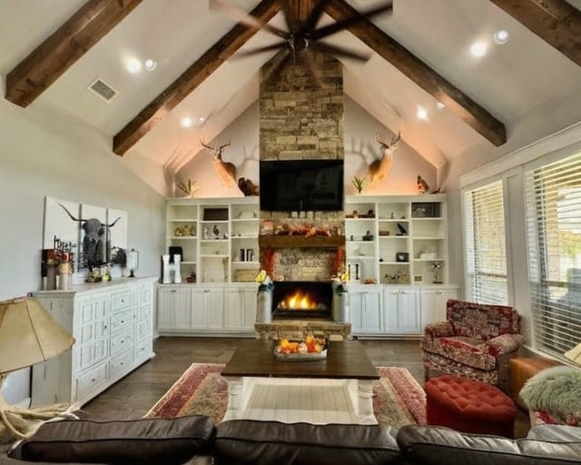 living room with high vaulted ceiling, a fireplace, beam ceiling, and dark wood-type flooring