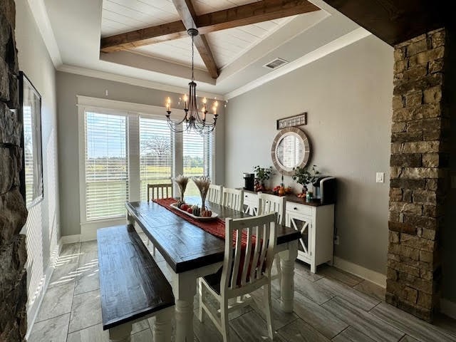 dining space featuring beamed ceiling and a chandelier