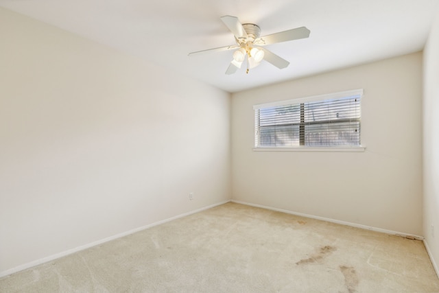 empty room featuring ceiling fan and light colored carpet