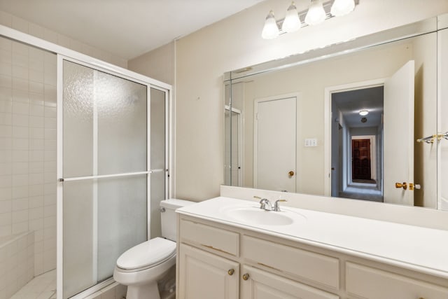 bathroom with vanity, a shower with shower door, and toilet