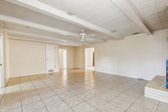 tiled spare room with beamed ceiling and ceiling fan