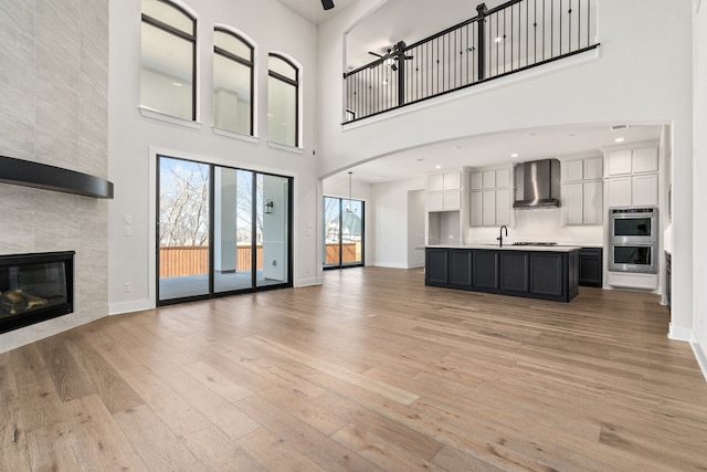 unfurnished living room with light wood-type flooring, a fireplace, and baseboards