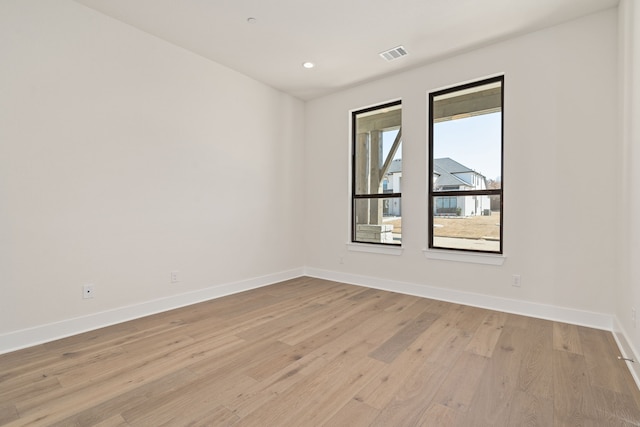 empty room with light wood-style flooring, recessed lighting, visible vents, and baseboards