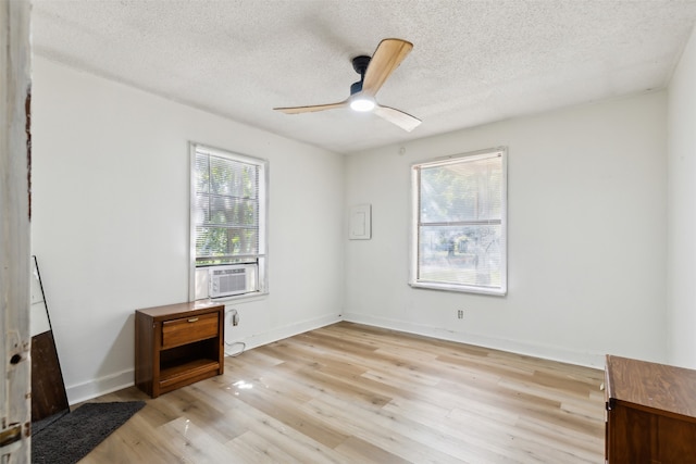 unfurnished room with ceiling fan, cooling unit, plenty of natural light, and light hardwood / wood-style flooring