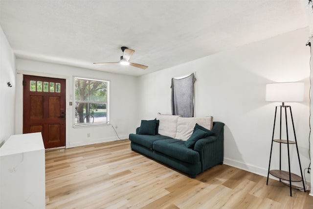 living room with ceiling fan and light hardwood / wood-style flooring