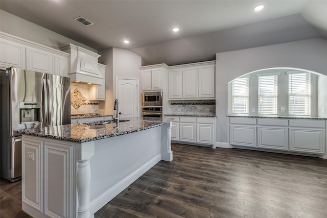 kitchen with white cabinetry, appliances with stainless steel finishes, sink, and a center island with sink