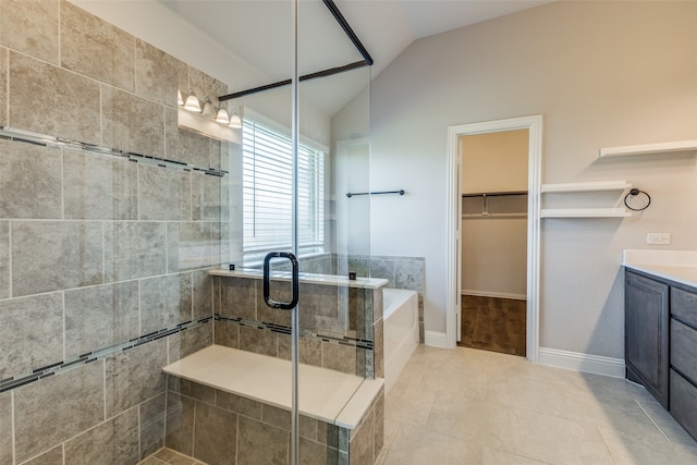 bathroom featuring vaulted ceiling, shower with separate bathtub, vanity, and tile patterned floors