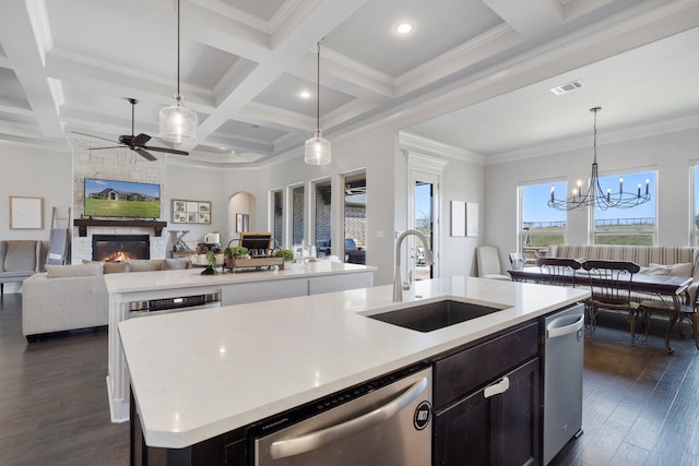 kitchen featuring dishwasher, a kitchen island with sink, beam ceiling, crown molding, and sink