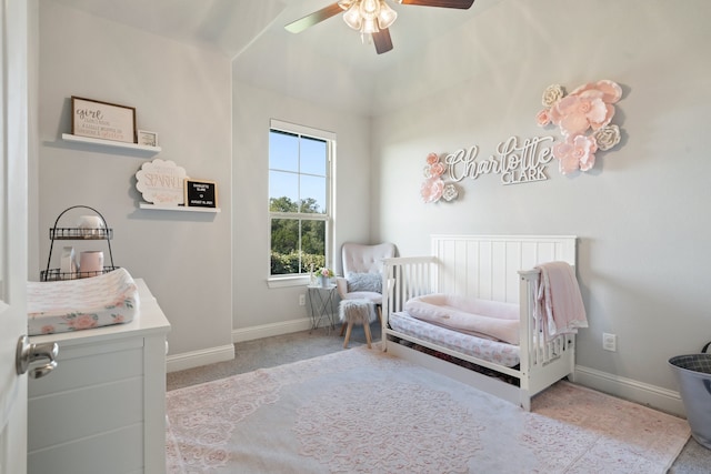 bedroom with ceiling fan and a nursery area