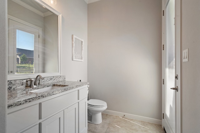 bathroom with toilet, tile patterned flooring, crown molding, and vanity