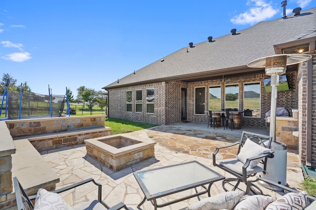 view of patio / terrace with a bar, a fire pit, and a trampoline