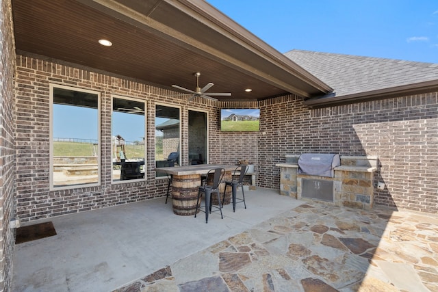 view of patio featuring ceiling fan, area for grilling, and an outdoor kitchen