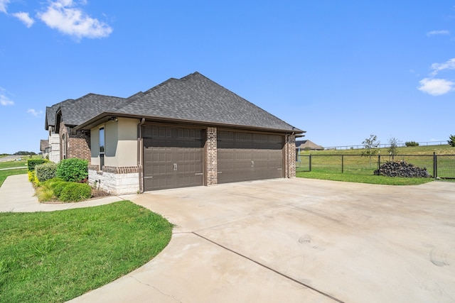 view of side of property featuring a garage and a lawn