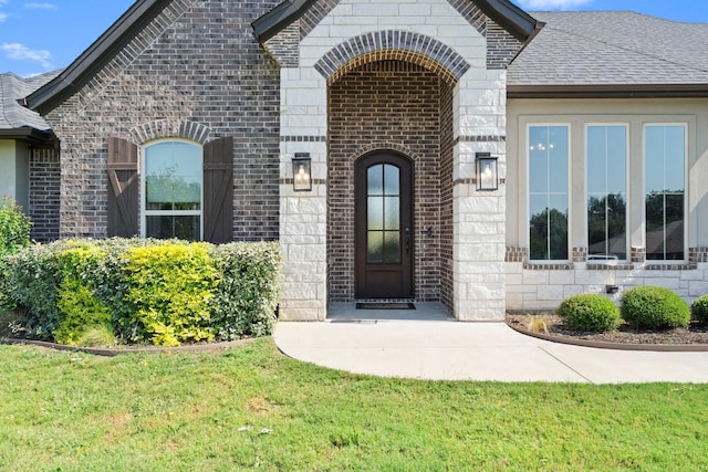 view of exterior entry with a yard