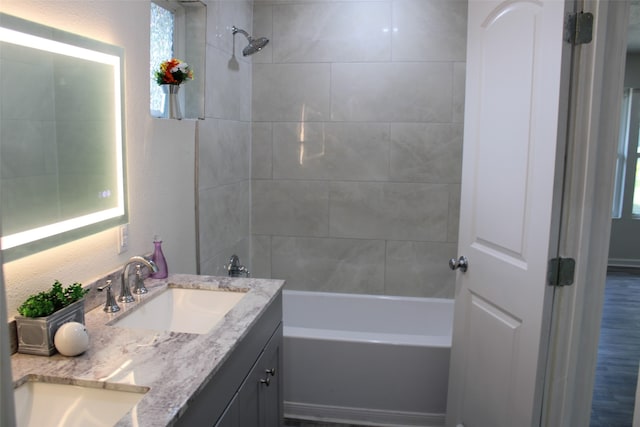 bathroom featuring vanity, tiled shower / bath combo, and hardwood / wood-style floors