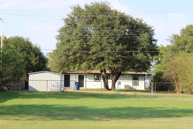 view of front of property with a front lawn and a storage unit