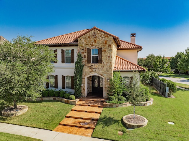 mediterranean / spanish house featuring a front yard