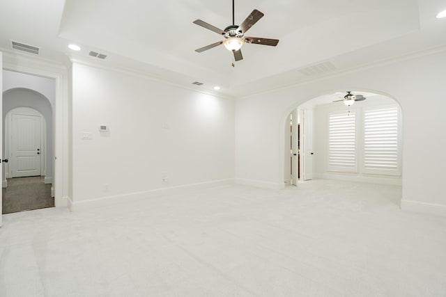 carpeted empty room featuring ornamental molding, ceiling fan, and a tray ceiling