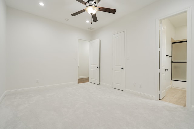 unfurnished bedroom featuring light carpet, ceiling fan, and ensuite bathroom