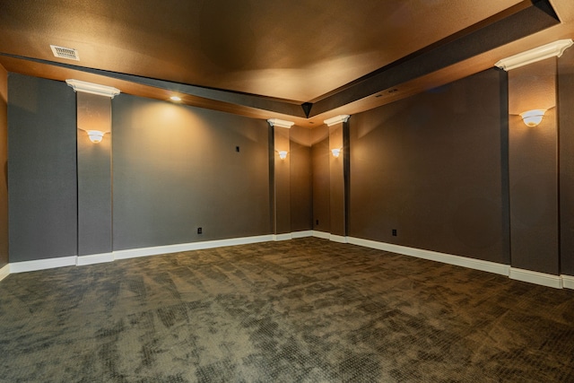 carpeted cinema featuring decorative columns and a tray ceiling