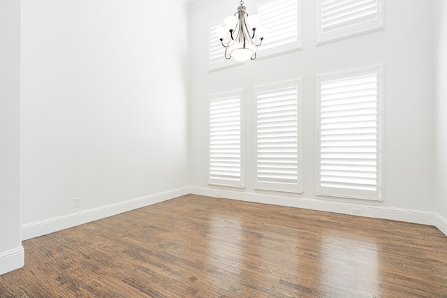 unfurnished dining area featuring dark hardwood / wood-style flooring and a notable chandelier