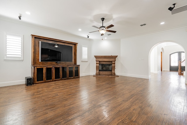 unfurnished living room with crown molding, dark wood-type flooring, and ceiling fan