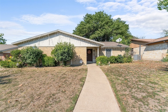 ranch-style home with central air condition unit and a front yard