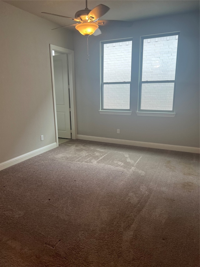 spare room featuring ceiling fan and carpet floors