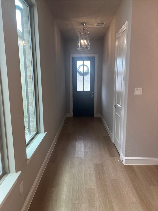 entryway featuring light hardwood / wood-style floors and a notable chandelier