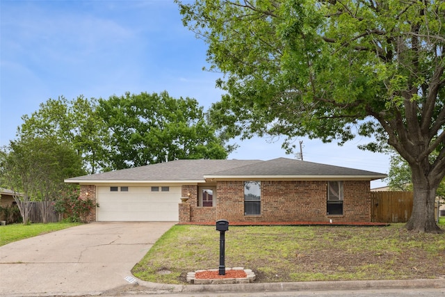 single story home with brick siding, concrete driveway, an attached garage, fence, and a front yard